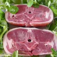 Dwa soczyste kotlety jagnięce otoczone świeżą sałatą. Zastanawiasz się, ile kosztuje kilogram jagnięciny?