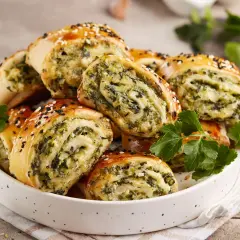 Roladki ze szpinakiem i serem, świetny pomysł na to, co można zrobić z ciasta na pizzę. Posypane sezamem.