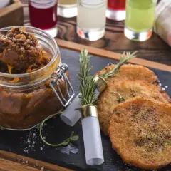 Czy bigos z kiszonej kapusty jest zdrowy? Ten aromatyczny bigos w słoiku i placki ziemniaczane na desce sugerują, że tak!