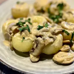 Pyszne kluski śląskie w kremowym sosie grzybowym z natką pietruszki. Idealny pomysł na to, jaki sos do klusek śląskich wybrać.