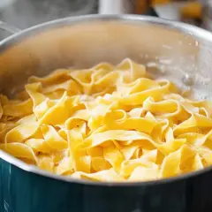 Szeroki makaron tagliatelle gotuje się w bulgoczącej wodzie. Kluczowe jest, ile wody na makaron, by był idealny.