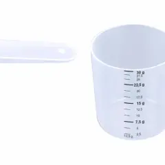 Dwie plastikowe miarki z podziałką w ml i g na białym tle.