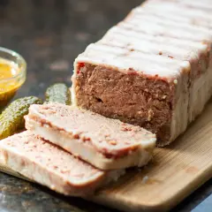 Pasztet zawinięty w boczek, pokrojony na plastry, z ogórkami i musztardą. Idealny do pieczenia w temperaturze 160°C.