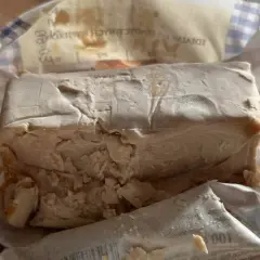 Kostka świeżych drożdży, lekko pokruszona, w opakowaniu. Zastanawiasz się, ile drożdże mogą być w lodówce?