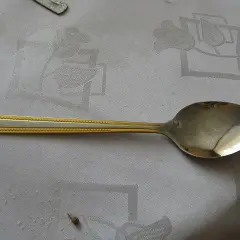 Stalowa łyżka stołowa z ozdobną, złotą rączką. Zastanawiasz się, ile mililitrów ma duża łyżka stołowa?