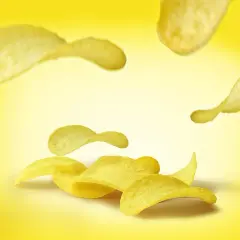 Chrupkie chipsy unoszą się na żółtym tle. Zastanawiasz się, ile kalorii mają chipsy?