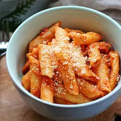 Penne w kremowym sosie pomidorowym, posypane parmezanem. Idealny sos śmietanowy do makaronu.