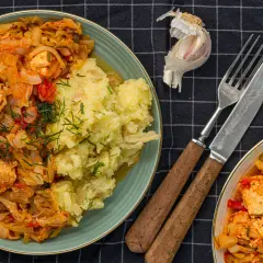 Pyszny bigos z kiszonej kapusty i mięsa, podany z ziemniakami. Zastanawiasz się, ile kalorii ma bigos z kiszonej kapusty?