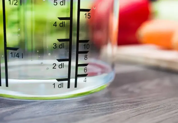 Miarka pokazuje, ile szklanka ma mililitrów wody. Woda sięga do poziomu 1 dl, czyli 100 ml.