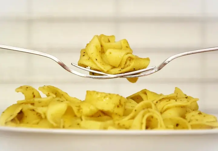 Pyszny makaron tagliatelle na widelcu, idealny pomysł, co zrobić z ugotowanym makaronem.