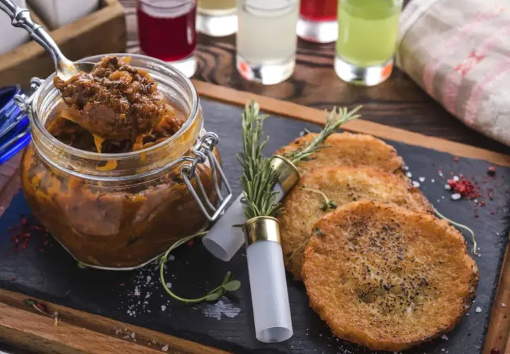 Czy bigos z kiszonej kapusty jest zdrowy? Ten aromatyczny bigos w słoiku i placki ziemniaczane na desce sugerują, że tak!
