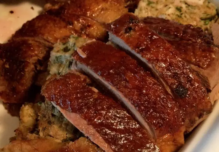 Gęś Ania gotuje. Pyszna, pieczona gęś z chrupiącą skórką i aromatycznym farszem, pokrojona na kawałki.
