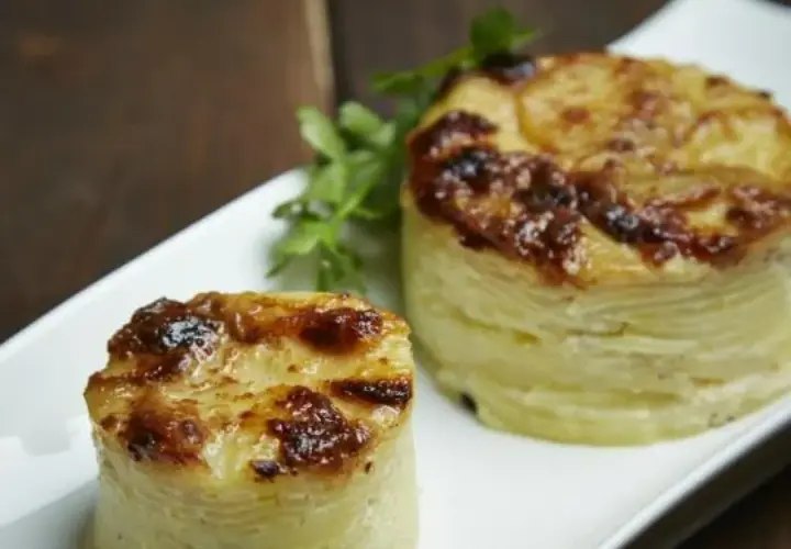 Dwa okrągłe, zapieczone ziemniaki gratin, idealne do podania jako dodatek. Pyszny przepis na ziemniaki gratin.