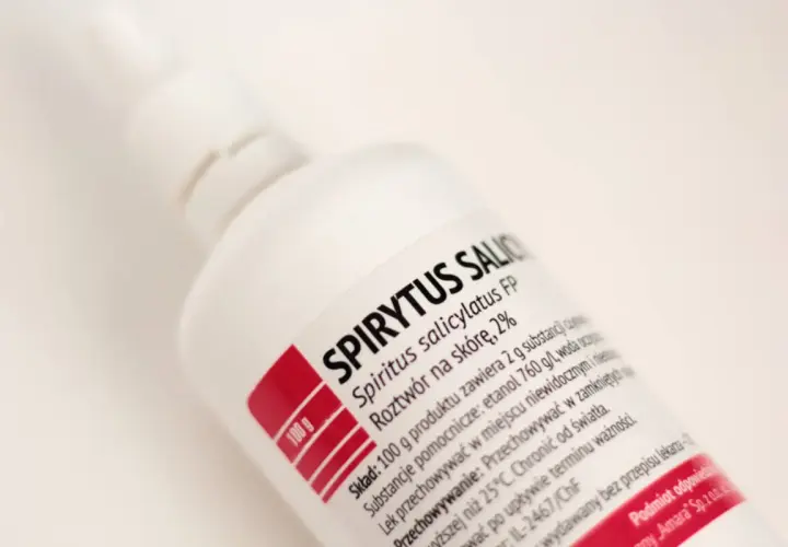 Biała butelka z etykietą "SPIRYTUS SALICYLATUS FP". Etykieta zawiera informacje o składzie, np. ile waży litr spirytusu.