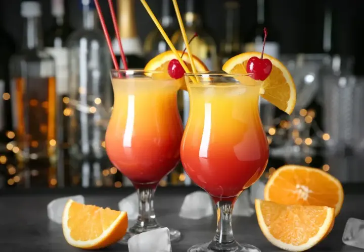 Dwa drinki z pomarańczą i wiśnią, idealne do nauki jak zrobić wódkę smakową.