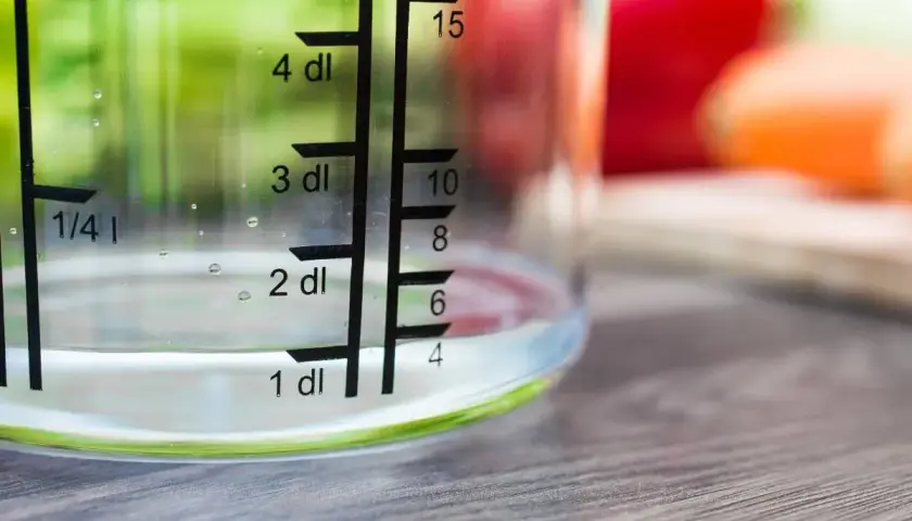 Miarka pokazuje, ile szklanka ma mililitrów wody. Woda sięga do poziomu 1 dl, czyli 100 ml.