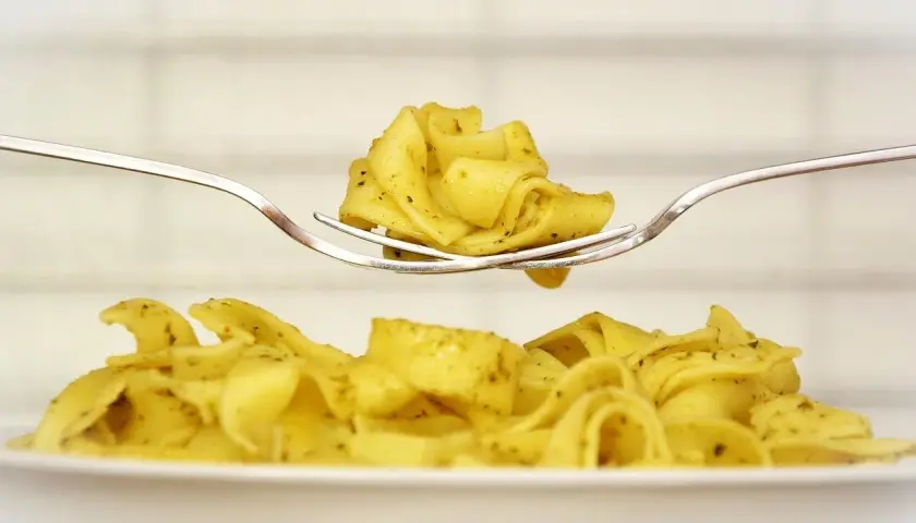 Pyszny makaron tagliatelle na widelcu, idealny pomysł, co zrobić z ugotowanym makaronem.