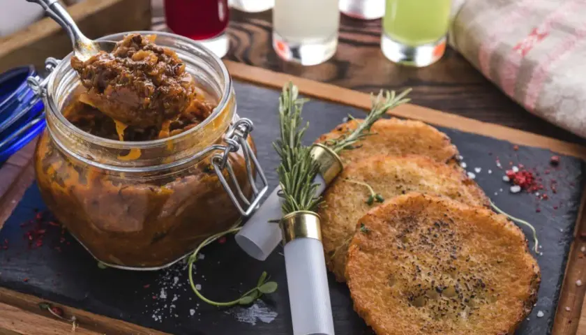 Czy bigos z kiszonej kapusty jest zdrowy? Ten aromatyczny bigos w słoiku i placki ziemniaczane na desce sugerują, że tak!