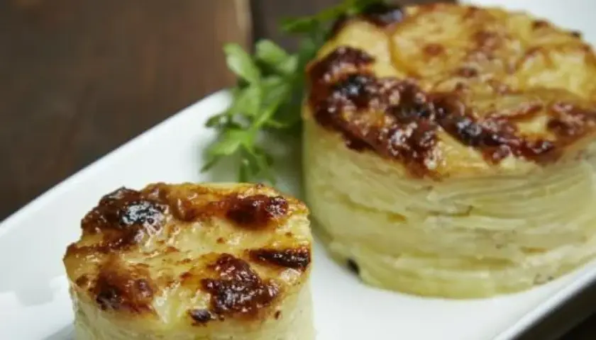 Dwa okrągłe, zapieczone ziemniaki gratin, idealne do podania jako dodatek. Pyszny przepis na ziemniaki gratin.