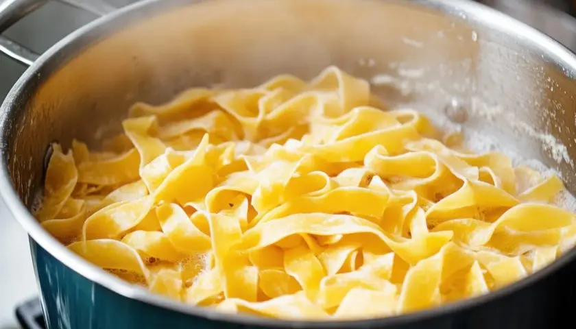 Szeroki makaron tagliatelle gotuje się w bulgoczącej wodzie. Kluczowe jest, ile wody na makaron, by był idealny.