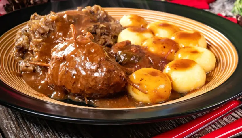 Pyszne mięso do klusek śląskich w sosie, podane z kapustą i ziemniaczanymi kluseczkami.