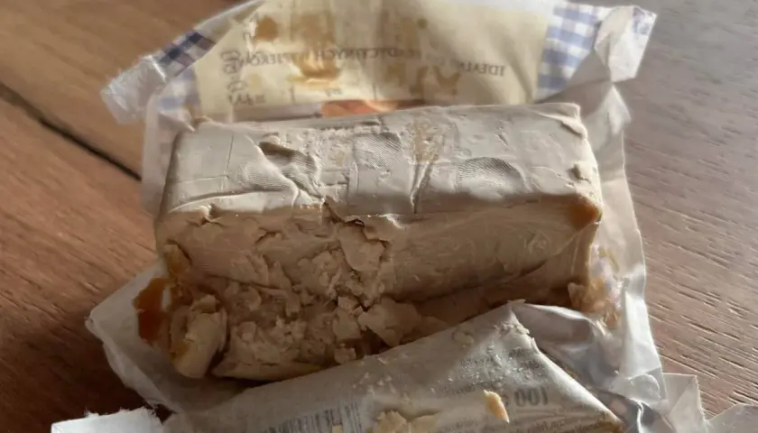 Kostka świeżych drożdży, lekko pokruszona, w opakowaniu. Zastanawiasz się, ile drożdże mogą być w lodówce?