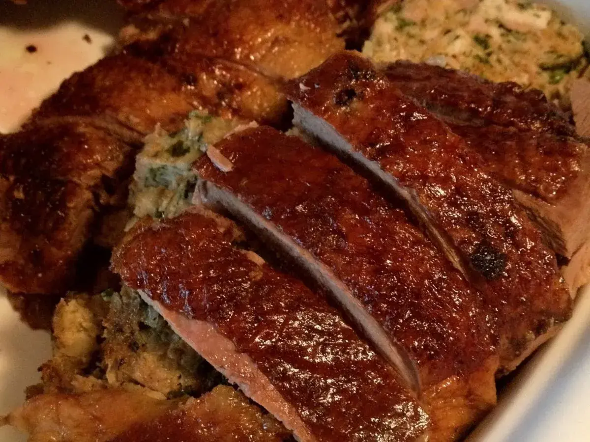 Gęś Ania gotuje. Pyszna, pieczona gęś z chrupiącą skórką i aromatycznym farszem, pokrojona na kawałki.