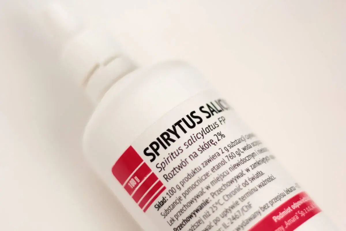 Biała butelka z etykietą "SPIRYTUS SALICYLATUS FP". Etykieta zawiera informacje o składzie, np. ile waży litr spirytusu.