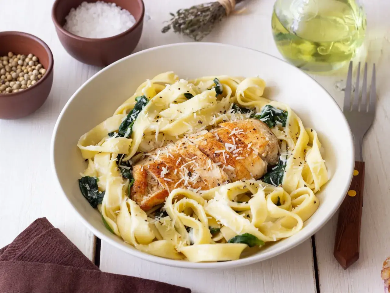 Szybki makaron z kurczakiem i szpinakiem, posypany parmezanem. Idealny na szybki obiad.