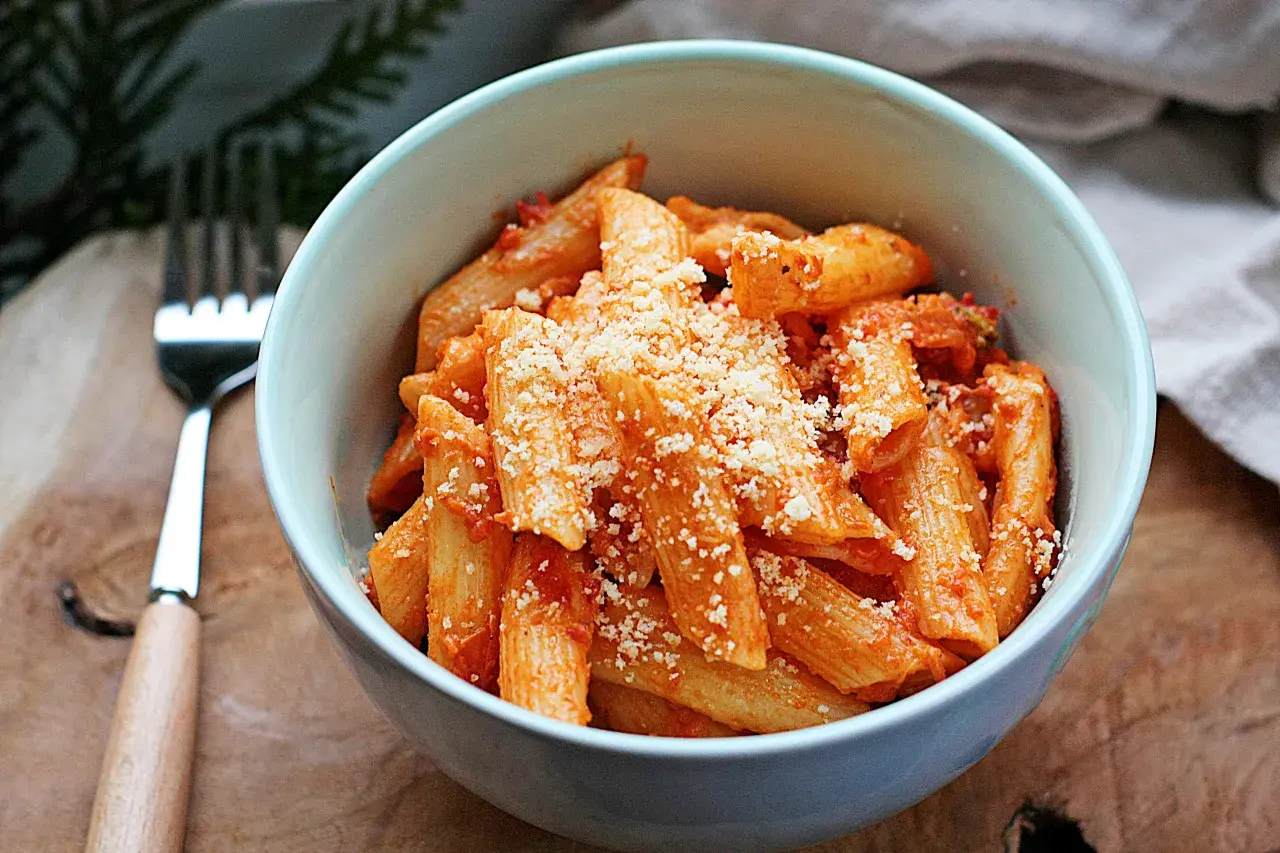 Penne w kremowym sosie pomidorowym, posypane parmezanem. Idealny sos śmietanowy do makaronu.