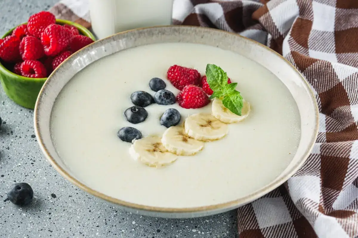 Pyszna kasza manna na wodzie, idealne proporcje, udekorowana malinami, borówkami, bananem i miętą.