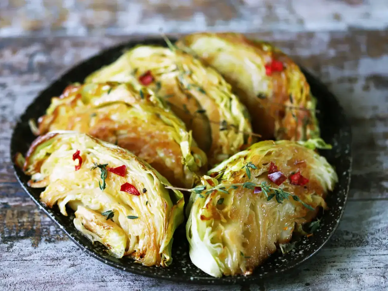 Pieczona kapusta w ćwiartkach, z chili i ziołami. Prosty przepis na kapustę pieczoną w piekarniku.