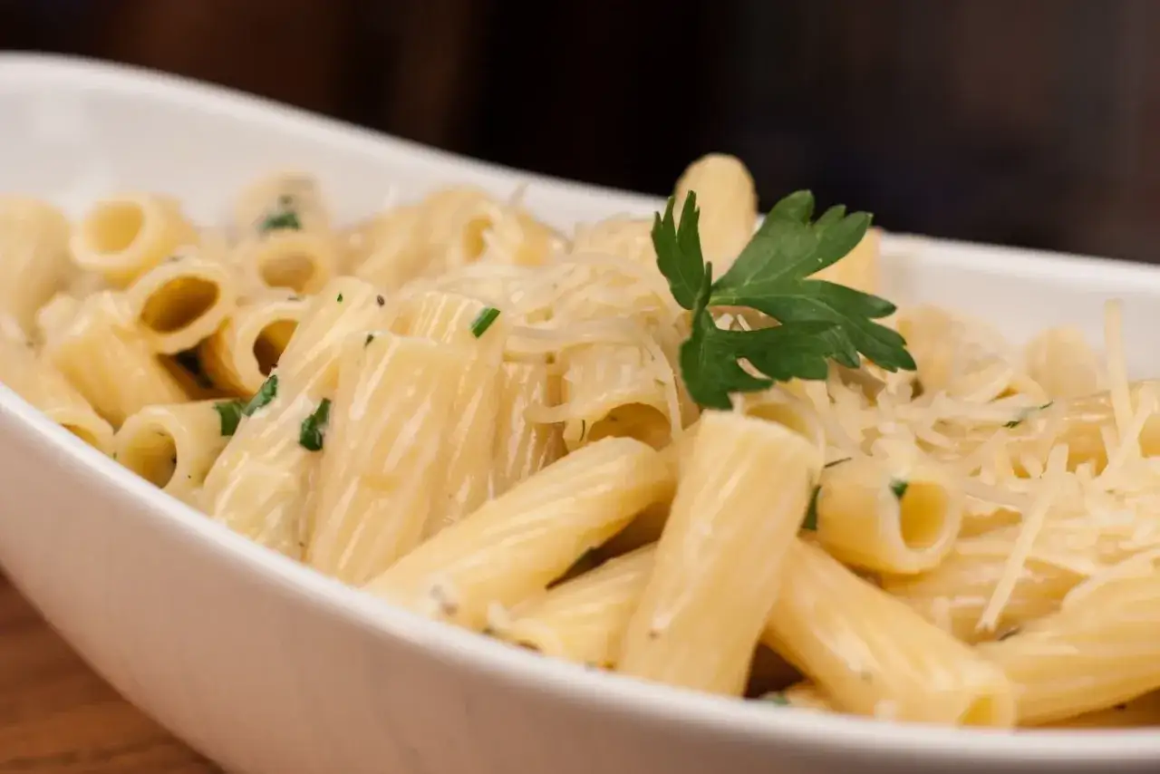 Pyszny makaron rigatoni w kremowym sosie serowym, posypany parmezanem i natką pietruszki. Idealny przepis na sos serowy do makaronu.